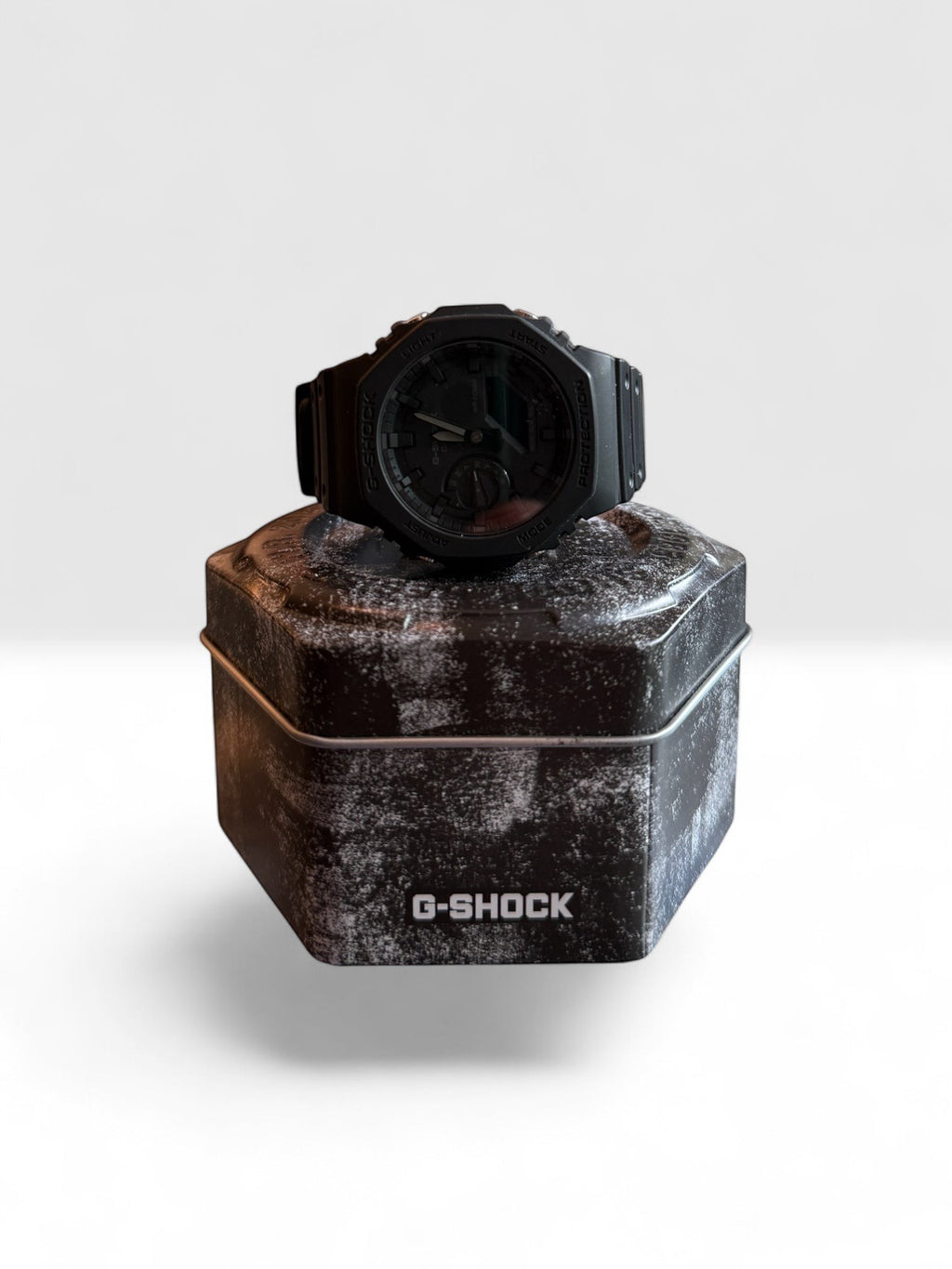 TimelessPieces by Marcel used black Casio G-Shock GA-2100 analog-digital watch on a distressed G-Shock tin.