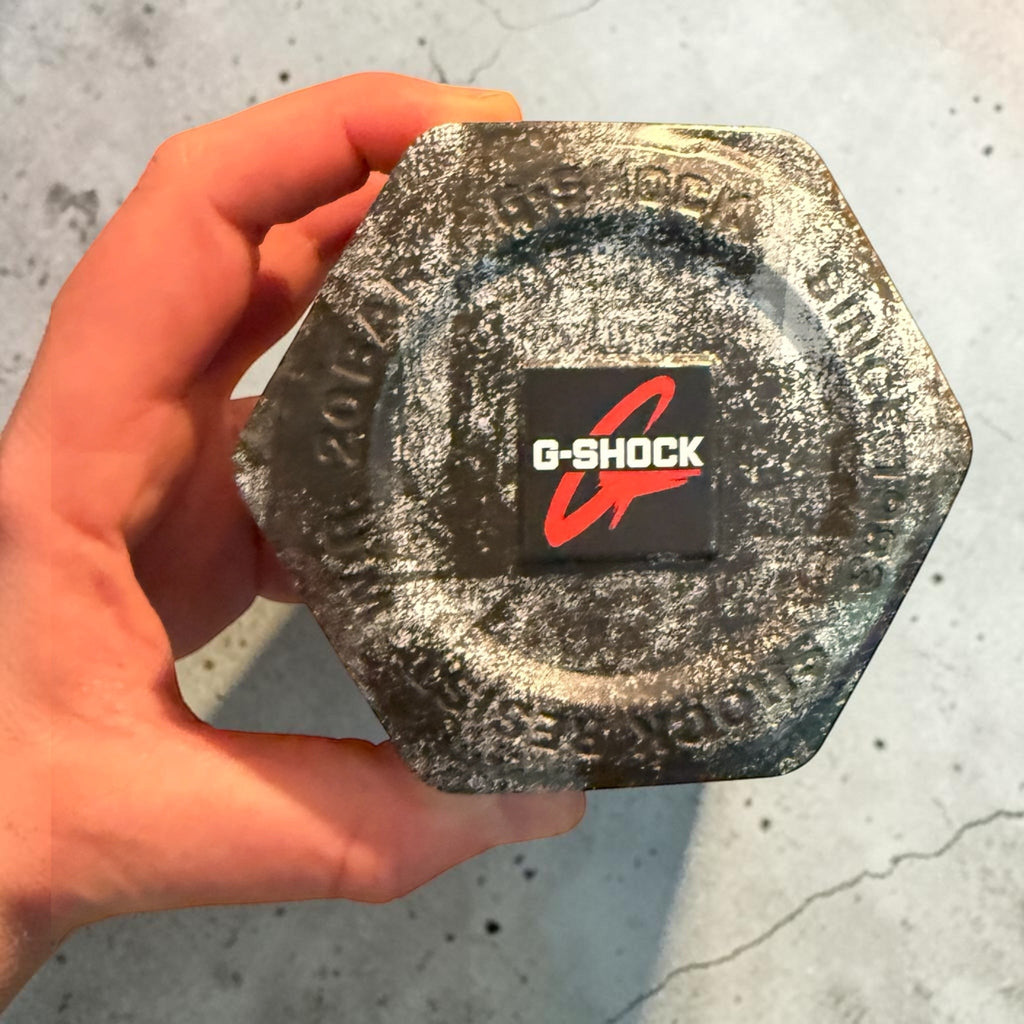 TimelessPieces by Marcel: Used black Casio G-Shock GA-2100 watch in hexagonal tin. Features red G-Shock logo.