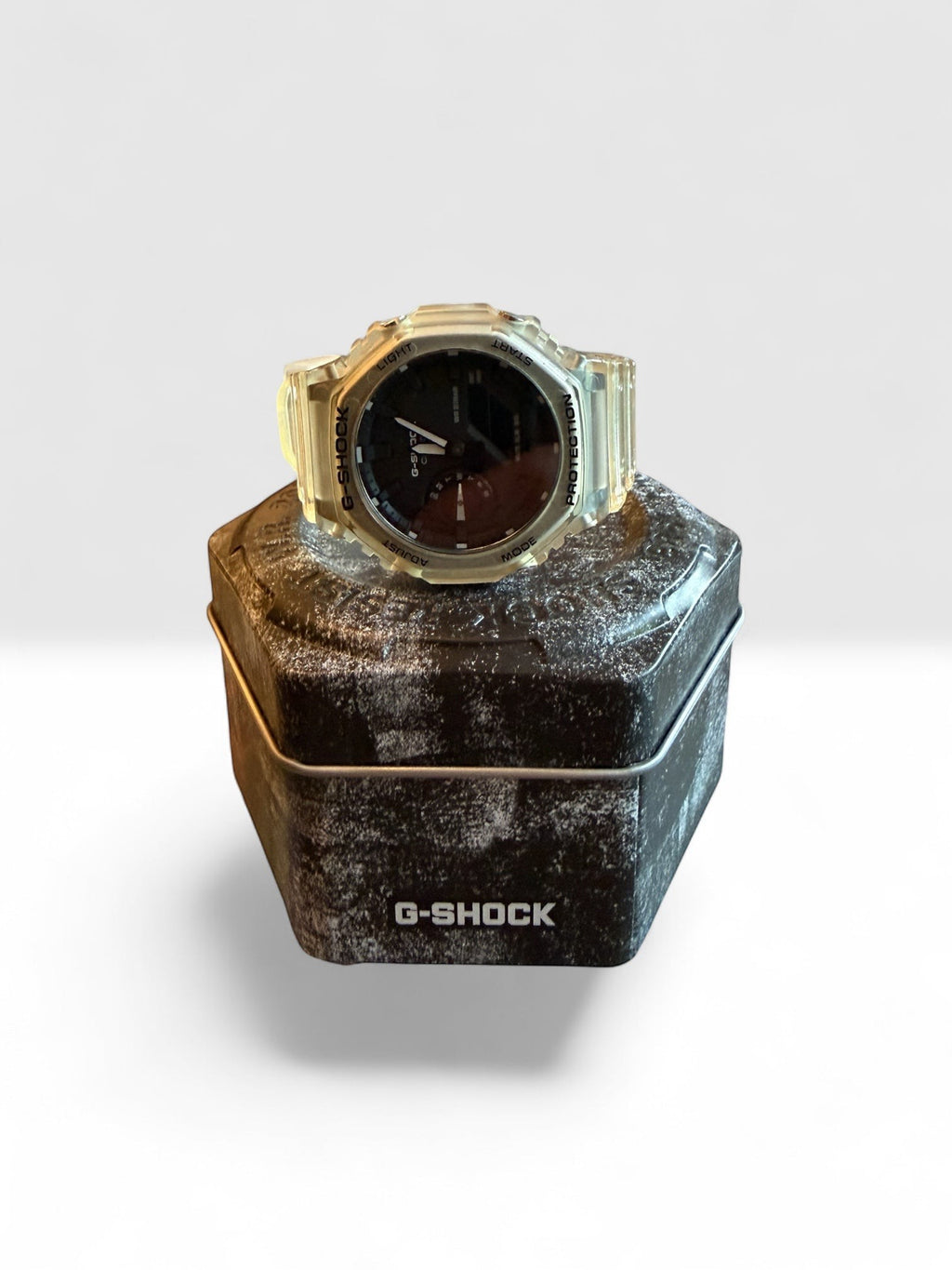 TimelessPieces by Marcel Casio G-Shock GA-2100 transparent analog-digital watch on a G-Shock tin.